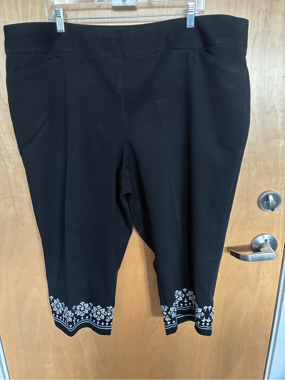 Black capris pants with embroidered white floral trim at hem size 24W